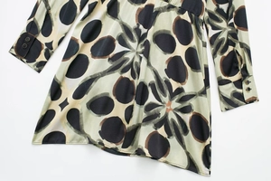 Détail de robe vert clair avec motifs floraux abstraits et poignets boutonnés élégants