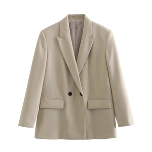Close-up detail of beige double-breasted blazer showing notch lapels and flap pockets