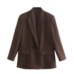 Detail view of peak lapel and flap pockets on a chocolate brown oversized blazer jacket