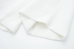 Detailed close-up showing the fine stitching and white twill fabric of wide leg trousers