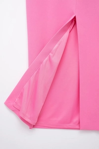 Detail of hot pink midi dress showing slit hem, premium fabric texture and matching lining