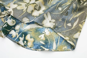 Détail de l'ourlet de la jupe plissée à fleurs montrant les coutures et le mousseline