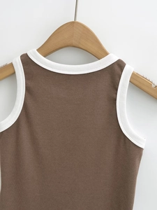 Detail of ribbed knit brown vest with white contrast piping on a wooden hanger