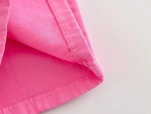 Detailed close-up of pink denim fabric texture with professional twin-needle stitching