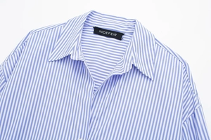 Close-up of the brand label on a blue and white striped cotton poplin shirt collar