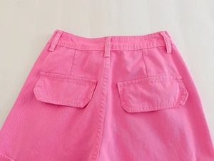 Macro shot of rose pink high waist cargo pants showing back pockets and twill denim texture