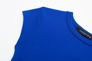 Detail shot of bright blue ribbed knit fabric with Indefeir neck label and stitching