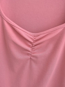 Detail of pink ribbed knit fabric featuring a V-neckline with center ruched drawstring design