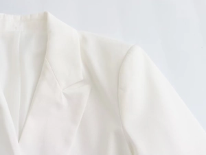 Close-up of elegant white blazer lapel and smooth shoulder tailoring in woven fabric
