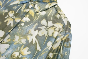 Gros plan sur le col d'une chemise en satin à fleurs et bouton avec coutures
