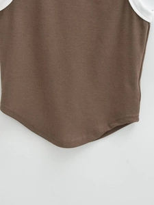 Detailed view of brown ribbed knit crop top featuring contrast white binding and curved hem