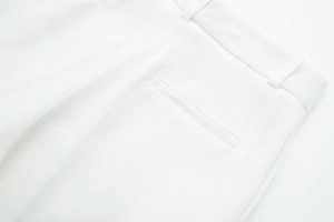 Detailed close-up of high-quality white twill pants waistline with precise stitching and rear pocket