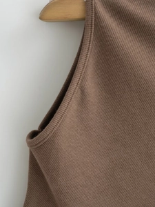 Dettaglio della trama in maglia a coste marrone e cuciture rifinite del top da donna