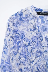 Detail view of the floral print ruffle layers on white long sleeve chiffon blouse