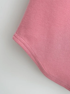 Close-up of pink ribbed knit fabric detail featuring neat double-needle stitching quality