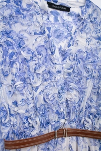 Detail of floral chiffon dress with ruffled layers and a slim brown leather belt