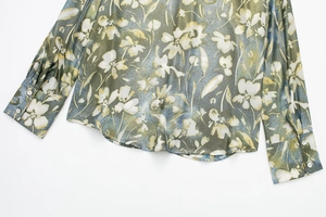 Détail du chemisier floral montrant des boutons blancs élégants et un tissu soyeux