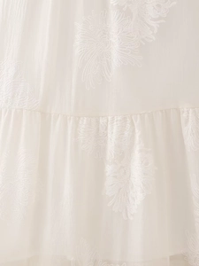 Macro shot of white chiffon fabric with delicate floral embroidery and pleat details