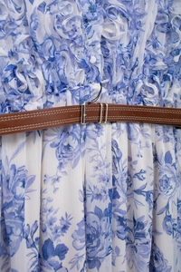 Detail of blue floral dress with layered ruffles and brown leather belt with metal buckle
