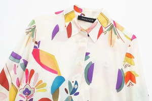 Detail of printed poplin shirt collar with colorful geometric patterns and branded label