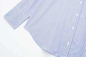 Detail of blue and white striped shirt showing rounded hem and white buttons