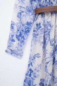 Detail of blue floral chiffon dress showing waist belt and ruffled neckline texture