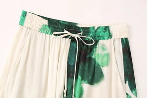 Détail de la taille élastique avec cordon sur le pantalon à imprimé tie-dye vert et blanc