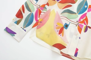 Detail of colorful abstract print on a white poplin shirt with white round buttons