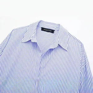 Close-up of a blue and white striped poplin shirt with a classic collar and brand tag