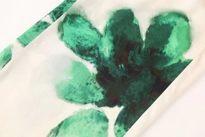 Vue détaillée du motif floral vert aquarelle sur le tissu léger de couleur blanche
