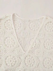 Close-up of white crochet hollow lace embroidery on a summer V-neck dress top
