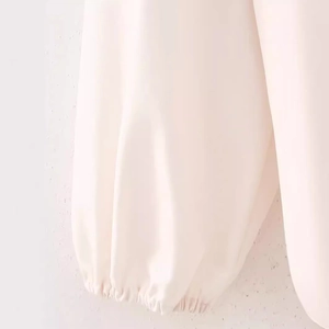 Gros plan de manches lanternes blanc crème avec poignets élastiques sur une chemise