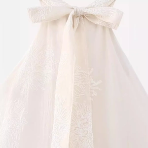 Elegant off-white halter neck jacquard dress featuring a large back bow and floral embroidery