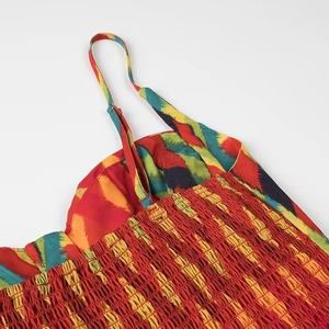 Detail of adjustable straps and elastic smocking on floral print summer dress