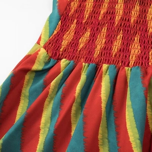 Close-up detail of smocking elastic craftsmanship on colorful vertical striped dress fabric