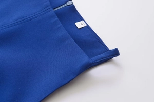 Détail de la robe bleue sans manches montrant les coutures précises et le zip assorti