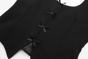 Détail du haut dos nu noir avec des nœuds en ruban délicats et un ourlet fendu élégant