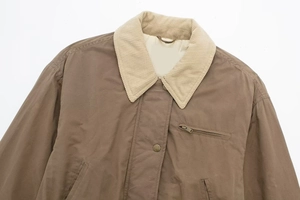 Detail view of brown flight jacket with corduroy collar and zip pockets in vintage style