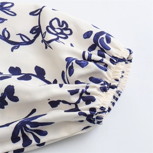 Detail of elastic ruffled cuffs on the long-sleeve dress with blue botanical prints