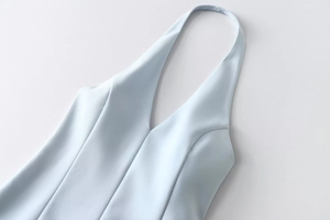 Detail of light blue halter dress featuring a deep V-neckline and structured princess seams