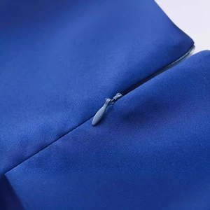 Détail de la robe courte bleu roi avec fermeture éclair invisible et texture de tissu lisse