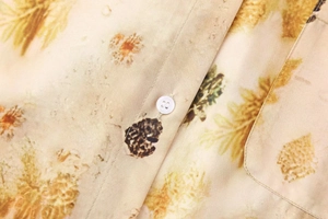 Detailed macro view of retro floral print shirt with white button and precise stitching