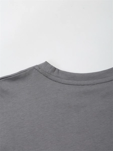 Detailed close-up of crew neckline stitching on dark grey cotton casual t-shirt