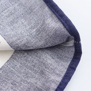 Detailed close-up of blue and white floral printed cotton linen fabric with neat stitching