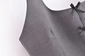 Détail du haut sans manches gris avec texture tissée et nœuds en ruban noir décoratifs