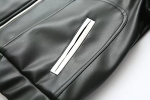 Vue détaillée de la veste en cuir noir avec bordures contrastées blanches sur la poche