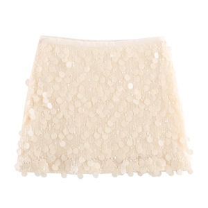 Close-up of cream sequin mini skirt showing detailed round discs and glossy texture