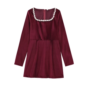 Detail of square neckline with rhinestone trim on deep burgundy velvet mini dress