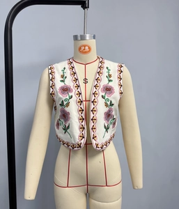 Detail of bohemian embroidery and floral patterns on vintage ivory vest waistcoat