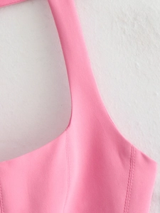 Close-up of pink slim-fit halter top showing refined stitching and woven fabric texture